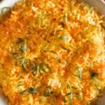 Carrot rice garnished with herbs