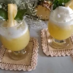 Two glasses of fresh pineapple juice with mint served on a marble counter