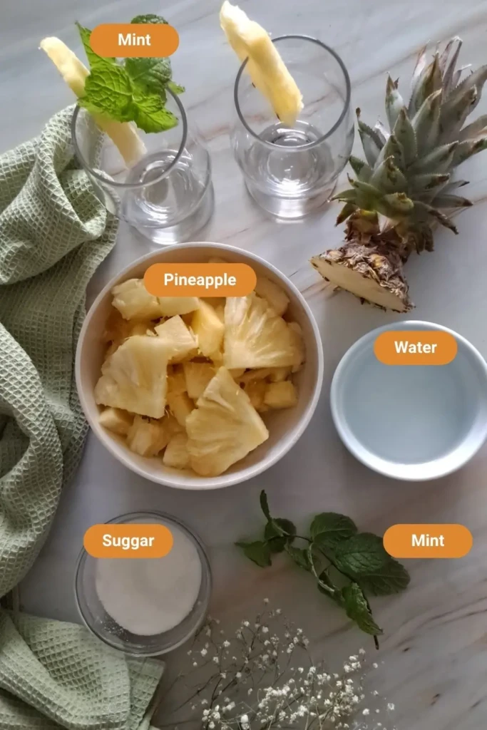 Pineapple juice with mint ingredients on a marble counter.